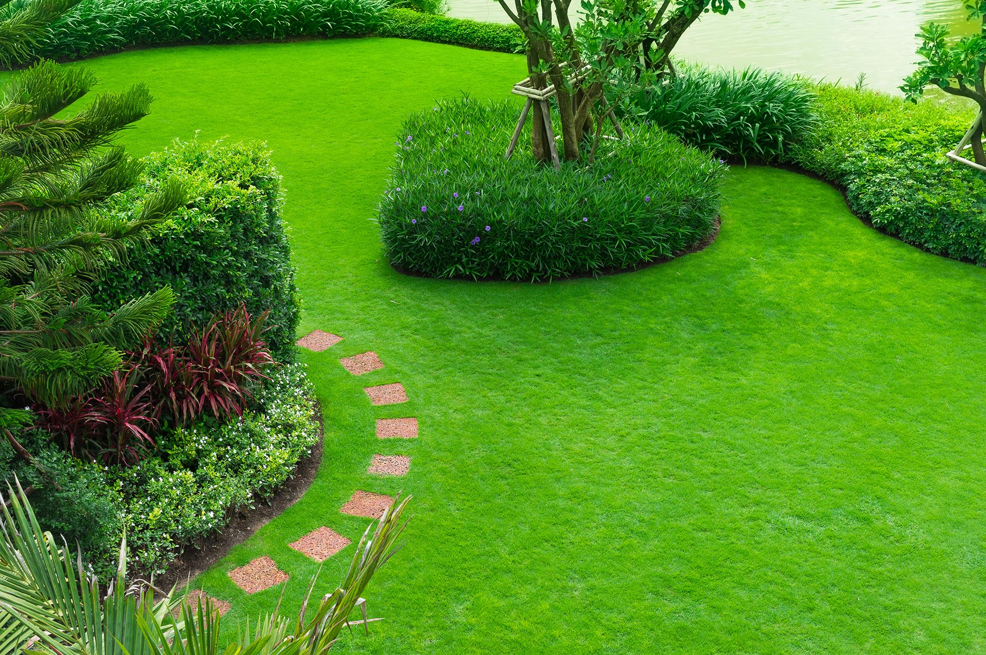 Manicured garden lawn beside a tranquil lake
